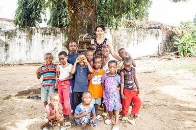 Children in Liberia gathered under a tree with a Heart In Heaven leader